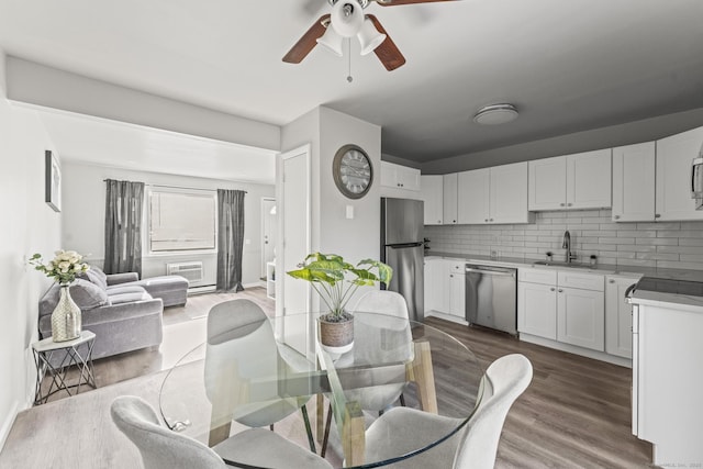 dining room featuring sink, hardwood / wood-style floors, and ceiling fan