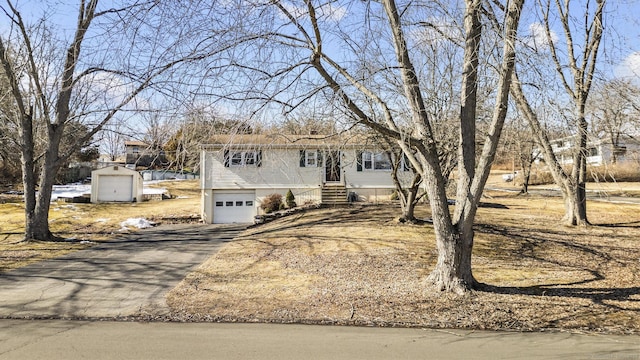 view of front of house featuring aphalt driveway, entry steps, and an attached garage