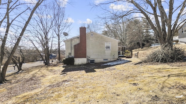 view of property exterior with central air condition unit and a chimney