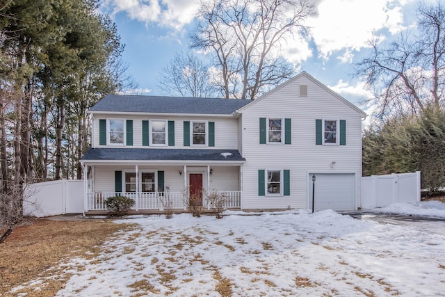 traditional home featuring a garage, a porch, and fence