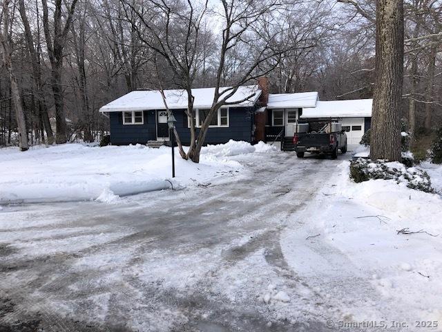 view of front of home featuring an attached garage and a chimney