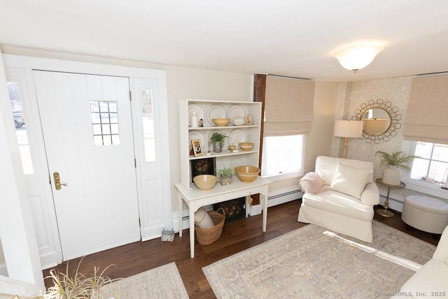 sitting room with dark hardwood / wood-style flooring and a baseboard heating unit