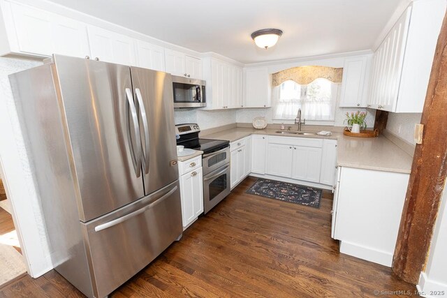 kitchen with white cabinetry, stainless steel appliances, dark wood-type flooring, and sink