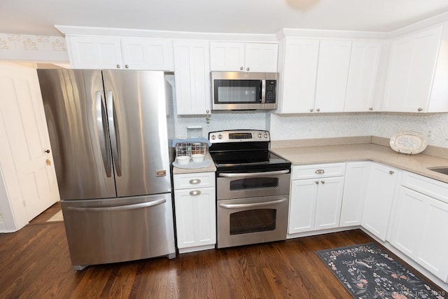 kitchen with appliances with stainless steel finishes, dark hardwood / wood-style floors, and white cabinets