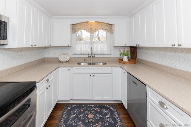 kitchen featuring appliances with stainless steel finishes, dark hardwood / wood-style flooring, sink, and white cabinets