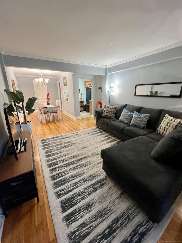 living room with crown molding, hardwood / wood-style floors, and a chandelier