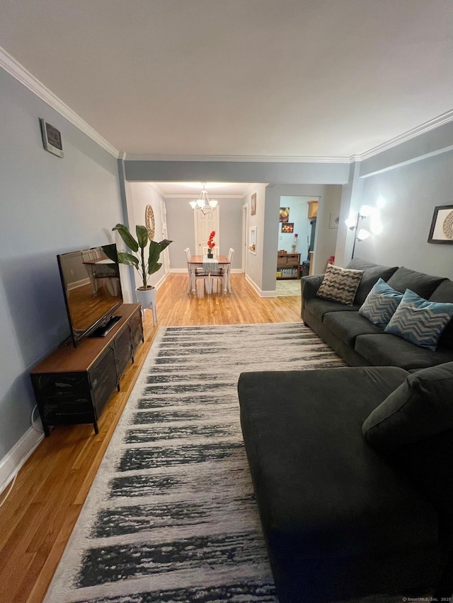 living room with hardwood / wood-style floors, a notable chandelier, and ornamental molding