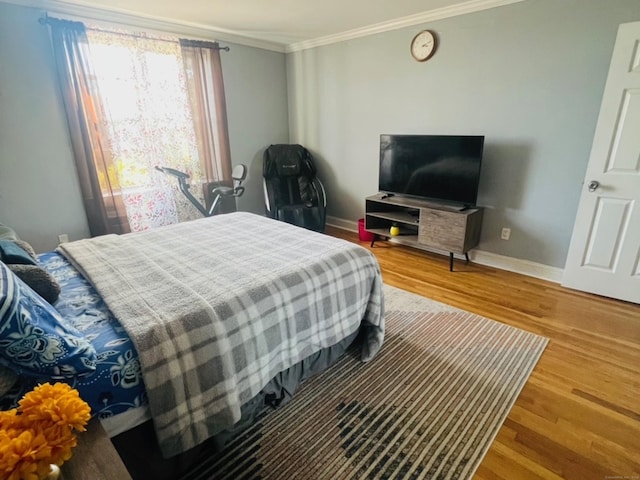 bedroom with crown molding and wood-type flooring