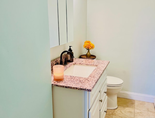 bathroom featuring vanity, tile patterned floors, and toilet