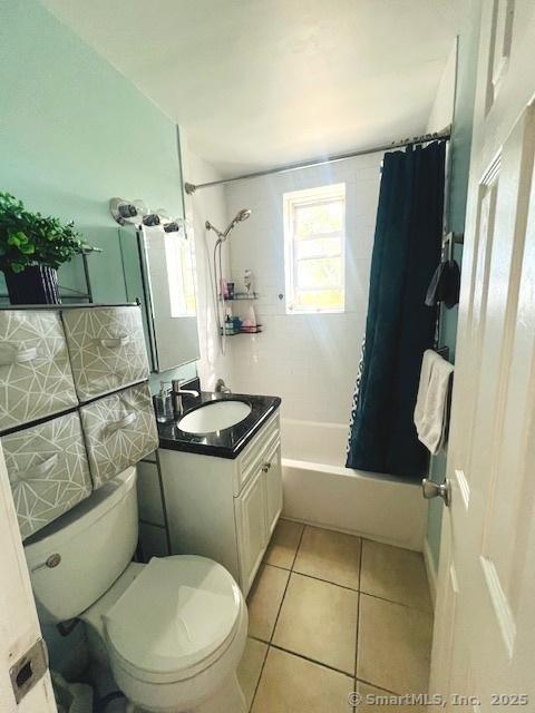 full bathroom with tile patterned flooring, vanity, shower / bath combo with shower curtain, and toilet