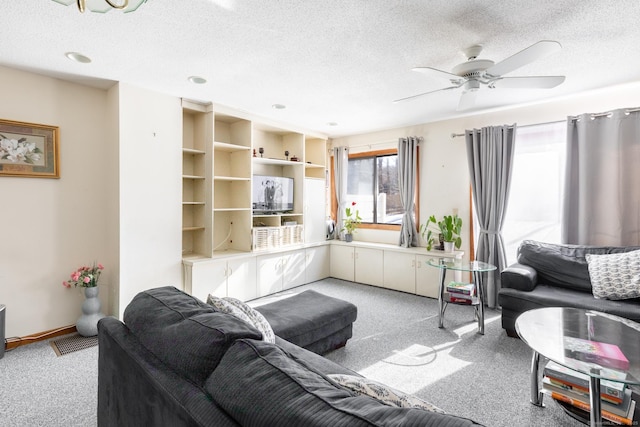 living area with visible vents, light colored carpet, and a textured ceiling