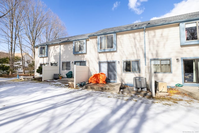 snow covered property with central air condition unit