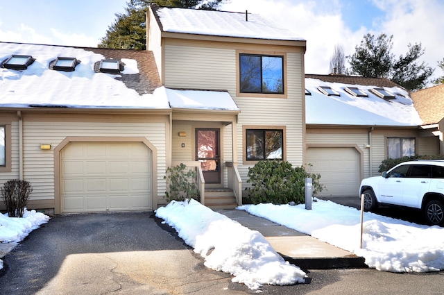 view of property featuring a garage, driveway, and roof with shingles