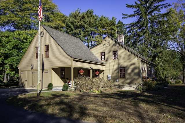 view of front of house with driveway and a chimney