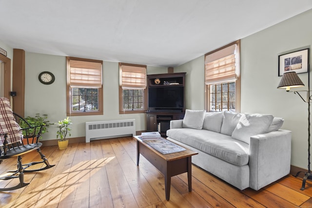 living room featuring hardwood / wood-style flooring, radiator heating unit, and baseboards