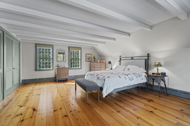 bedroom with a baseboard heating unit, hardwood / wood-style floors, baseboards, baseboard heating, and vaulted ceiling with beams