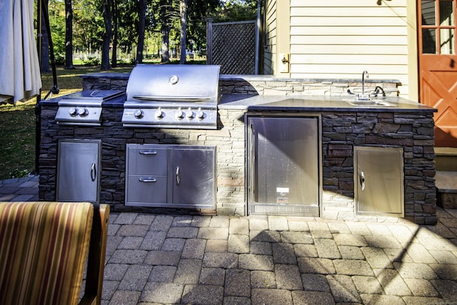 view of patio with a sink, exterior kitchen, and a grill