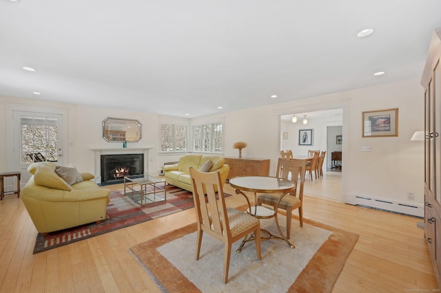 dining space featuring baseboard heating and light wood-type flooring