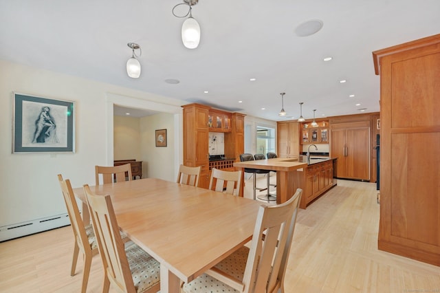 dining space with sink and light wood-type flooring