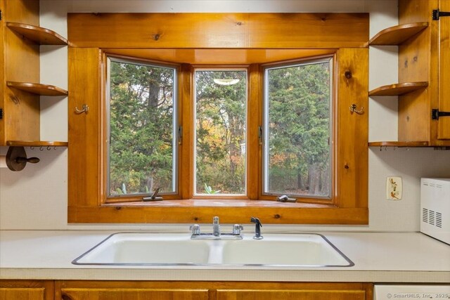 31 Pawson Rd, Branford, CT 06405 - kitchen with brown cabinets, open shelves, light countertops, a sink, and white dishwasher
