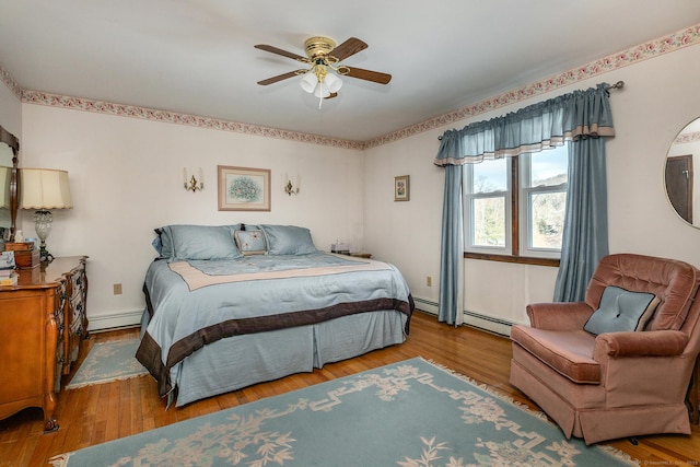 bedroom with ceiling fan, baseboard heating, and light wood-type flooring