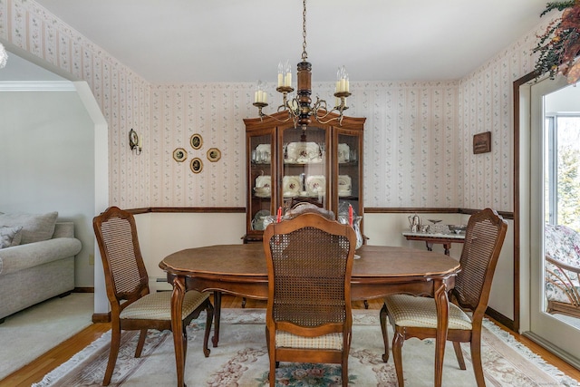 dining space with light wood-style floors, a notable chandelier, baseboards, and wallpapered walls