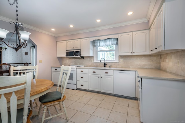 kitchen with white appliances, white cabinets, decorative light fixtures, light countertops, and a sink