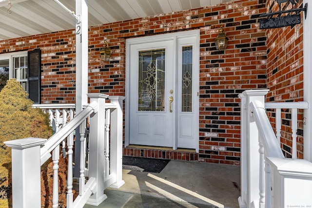 entrance to property featuring brick siding