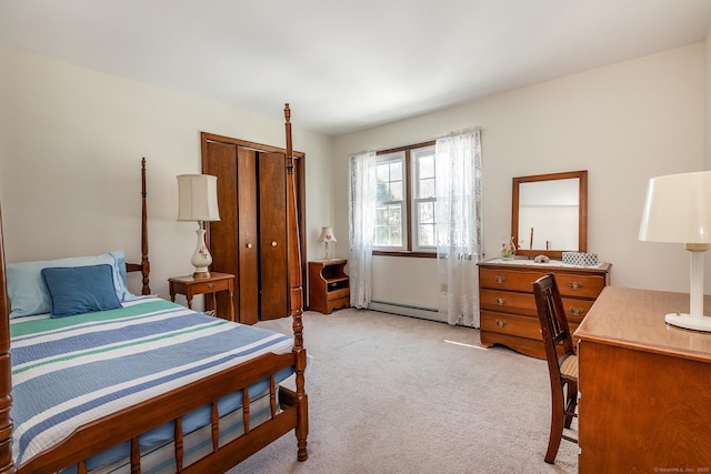 bedroom with a baseboard heating unit, a closet, and light colored carpet