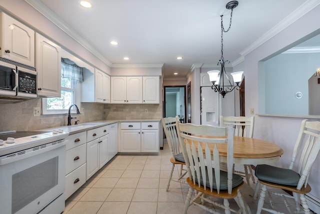 kitchen with white appliances, a sink, white cabinetry, light countertops, and hanging light fixtures