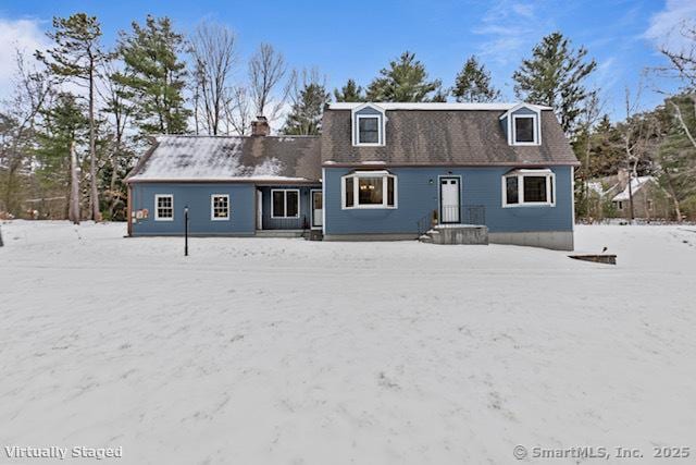 snow covered property with a chimney