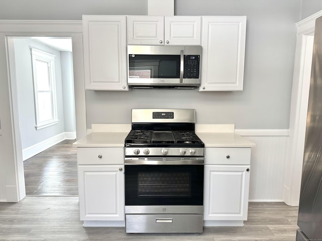 kitchen with light countertops, appliances with stainless steel finishes, and white cabinetry