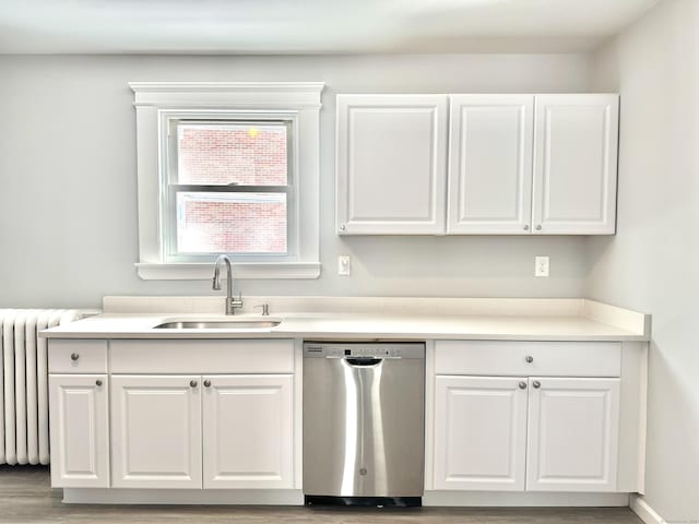 kitchen featuring dishwasher, radiator heating unit, light countertops, white cabinetry, and a sink