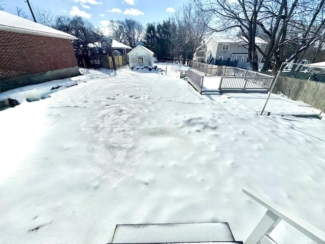 snowy yard featuring fence and a residential view