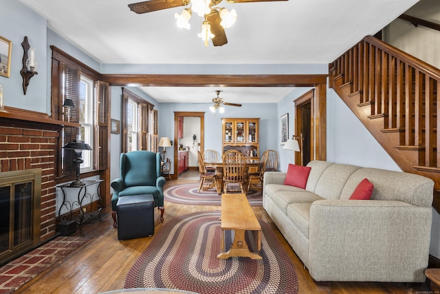 living room with hardwood / wood-style flooring, a fireplace, and ceiling fan