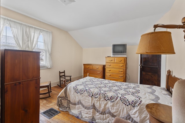 bedroom featuring vaulted ceiling and light hardwood / wood-style floors