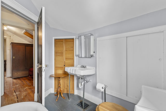 bathroom with lofted ceiling, sink, and a tub