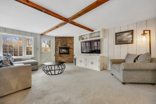 carpeted living room featuring a brick fireplace and beam ceiling