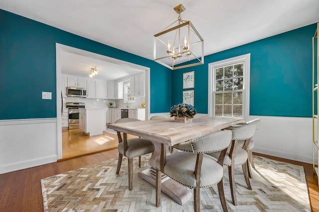 dining space featuring a notable chandelier and light wood-type flooring