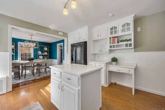 kitchen featuring white cabinets, pendant lighting, a kitchen island, and stainless steel fridge with ice dispenser