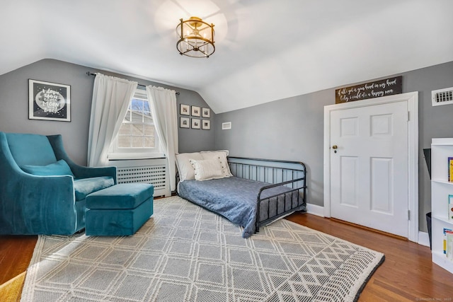 bedroom with hardwood / wood-style flooring and lofted ceiling