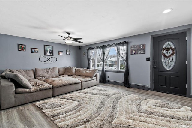 living room featuring a baseboard radiator, light hardwood / wood-style floors, and ceiling fan