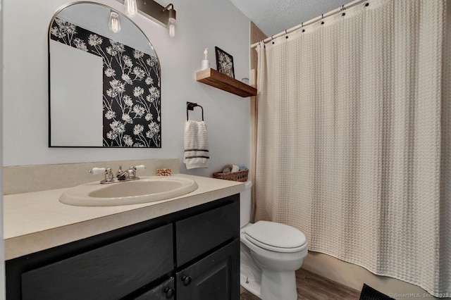 full bathroom featuring a textured ceiling, toilet, wood finished floors, vanity, and a shower with curtain