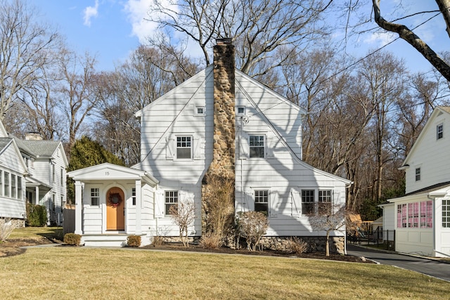 view of front of house featuring a chimney and a front yard