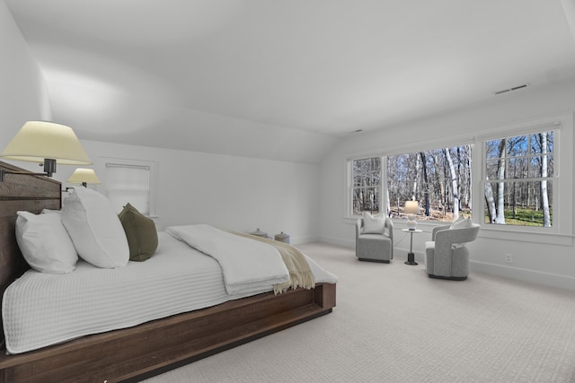 carpeted bedroom with vaulted ceiling, visible vents, and baseboards