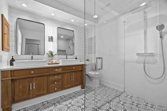 bathroom featuring double vanity, a sink, and a shower with shower door