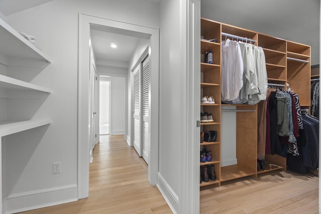 walk in closet with light wood-style flooring