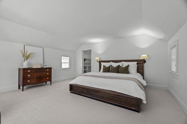 carpeted bedroom with vaulted ceiling and baseboards