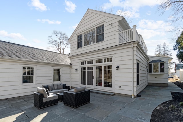 back of house featuring a shingled roof, a balcony, french doors, a patio area, and an outdoor living space