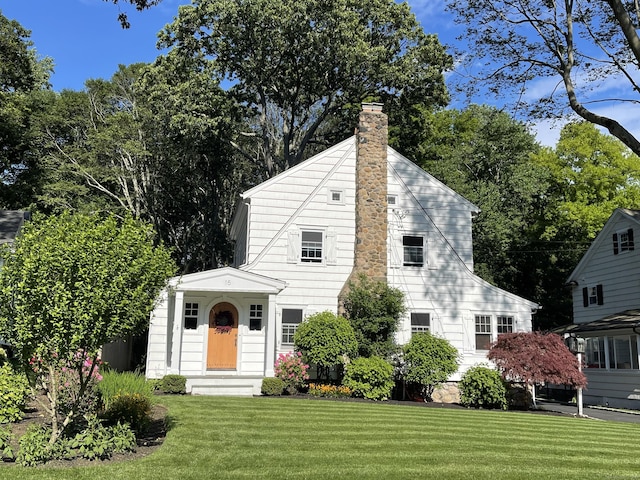 view of front of home with a front yard and a chimney